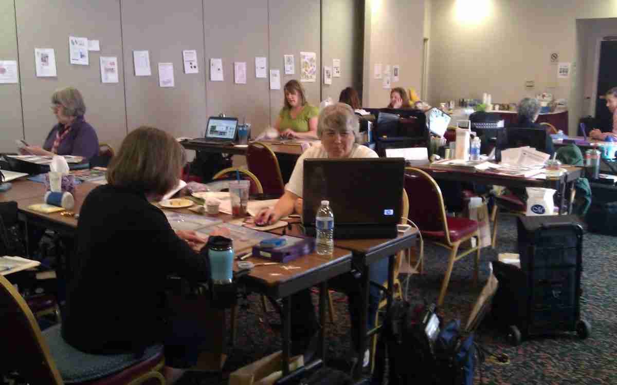 women working on computers and photo albums at workshop