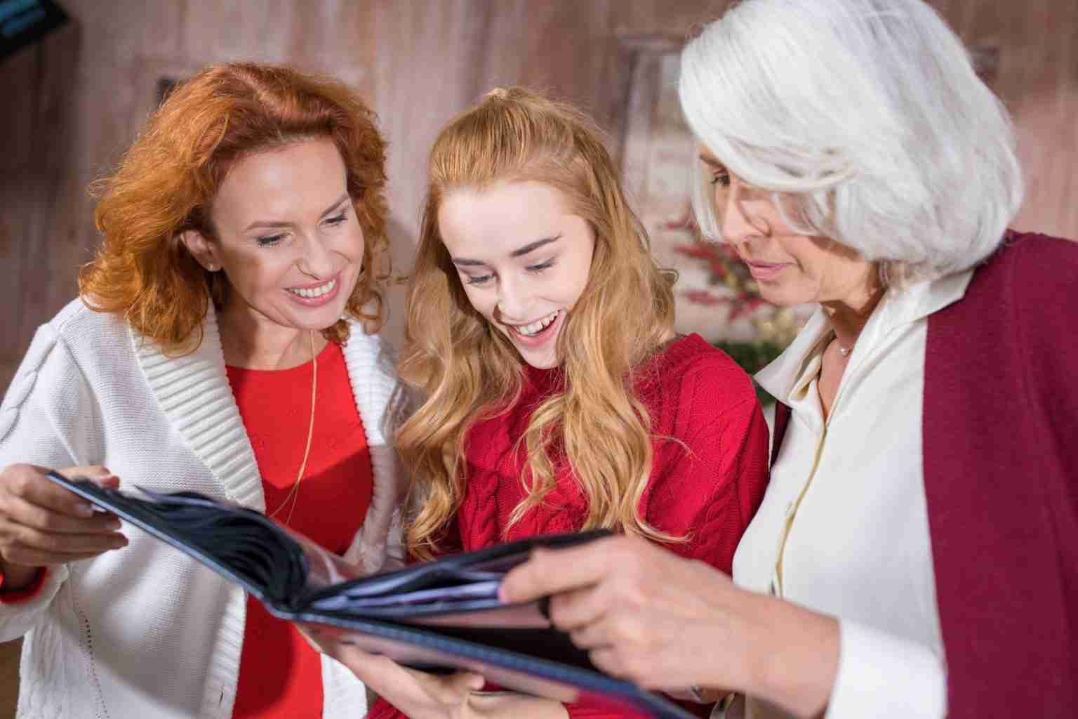 A mother, daughter and grandmother looking at the photo book together