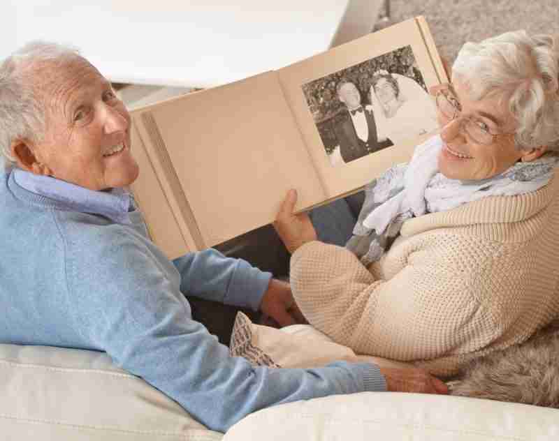 a mature man and woman looking at a photobook