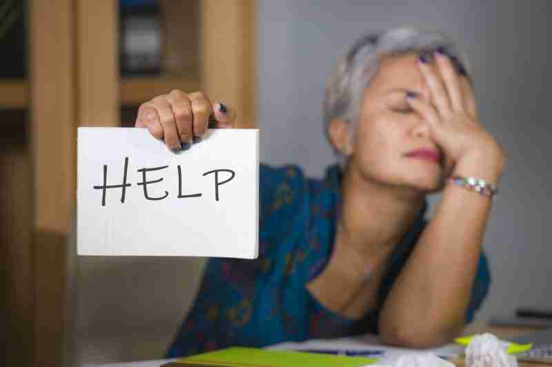 a woman holding a sign with her hand that asks for help with her family photo organization