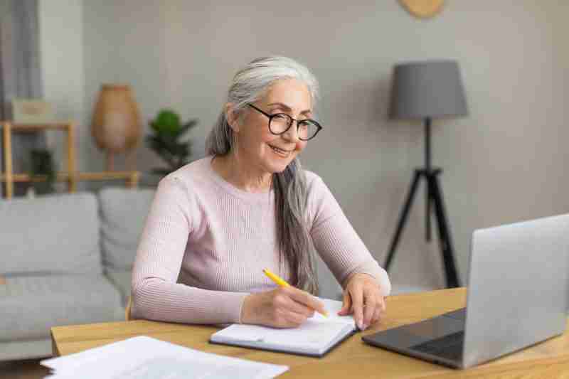a mature woman attending a photo coaching meeting on her computer